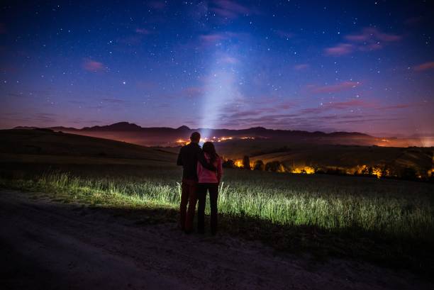 istock Young happy couple hugging at starry night in mountains. 962995390