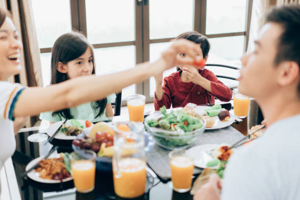 istock Family laughing around a good meal 962998874