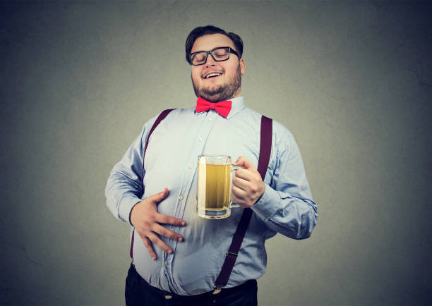 тучный молодой человек, полный пива - pot belly стоковые фото и изображения