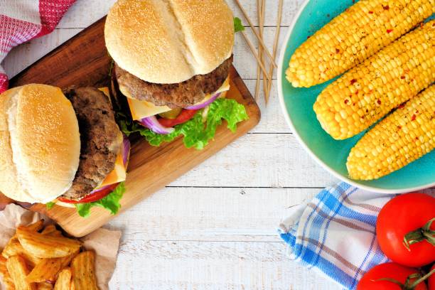 scena piknikowa z hamburgerami, klinami kukurydzy i ziemniaków - grilled vegetable tomato barbecue zdjęcia i obrazy z banku zdjęć