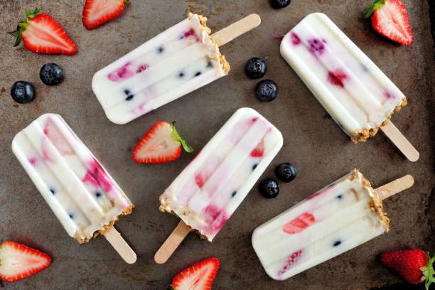 istock Mixed berry yogurt popsicles with granola over a dark background 963011918