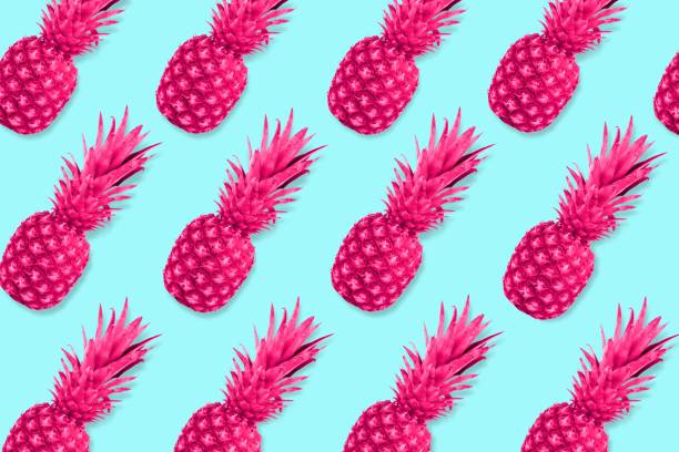 istock Fruit pattern of neon pink pineapples on a pastel blue background 963015218