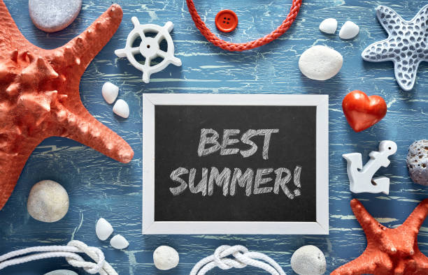 istock Blackboard with sea shells, stones, rope and star fish on blue wood, text 963034470