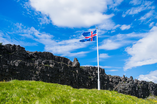The Iceland flag in front of the tectonic plate, between Europe and America.