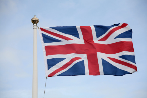 Online education concept with UK flag next to a laptop on table