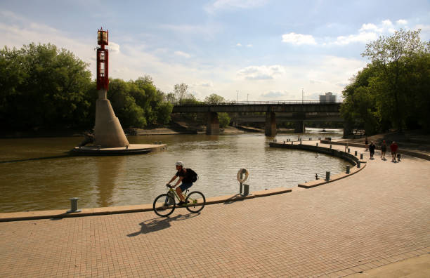 a young man riding a bike in a beautiful sunny day - winnipeg river imagens e fotografias de stock