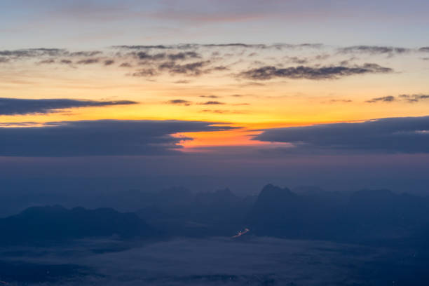 Photo of Mountain silhouette above the clouds at sunrise, view from the top view of mountains.