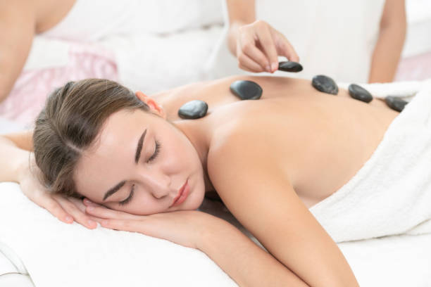 istock Hot stone massage treatment by therapist in spa. 963087490