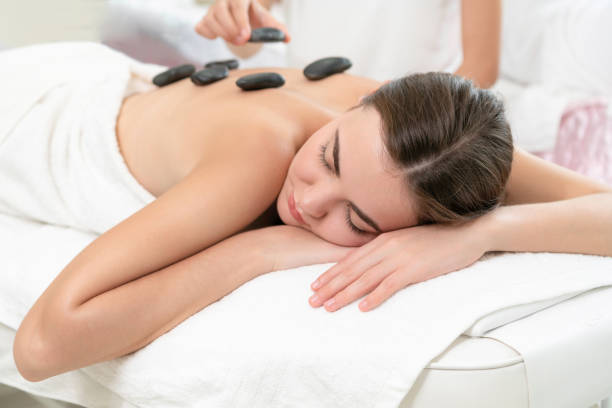 istock Hot stone massage treatment by therapist in spa. 963087502