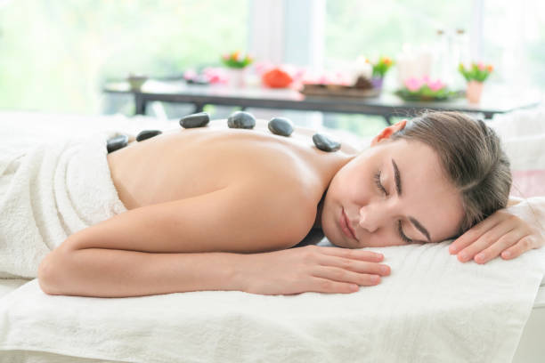 istock Hot stone massage treatment by therapist in spa. 963087574