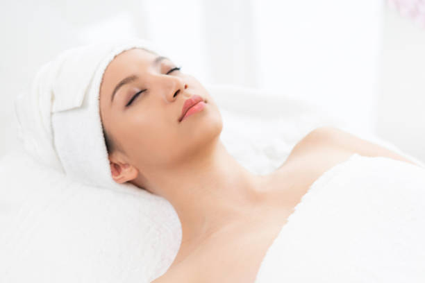 istock Relaxed young woman lying on spa bed for massage. 963087644
