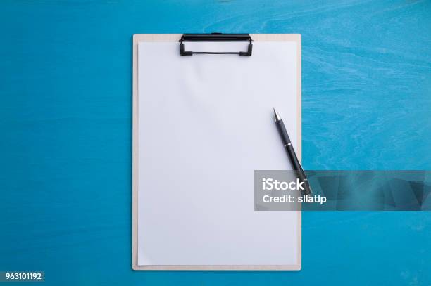 A4 Clipboad On Blue Wood Table Stock Photo - Download Image Now - Clipboard, Paper, Backgrounds