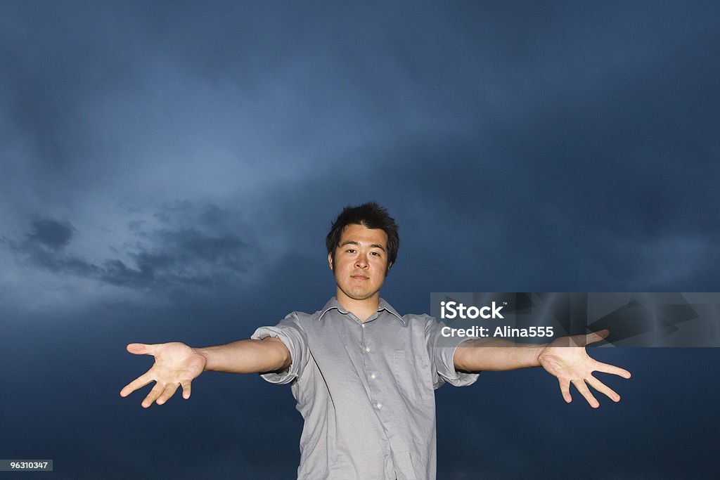 Homem com as mãos aganst Céu Tempestuoso Fique - Foto de stock de Acordo royalty-free