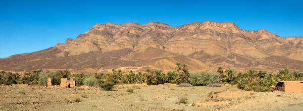 istock Moroccan clay houses near mountains and palms 963108870