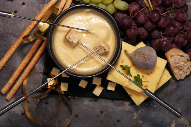 istock Gourmet Swiss fondue dinner on a winter evening with assorted cheeses on a board alongside a heated pot of cheese fondue 963113918