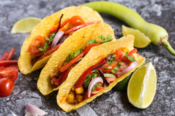 istock Mexican Tacos in Corn Shells with Vegetables on Stone Background 963114130
