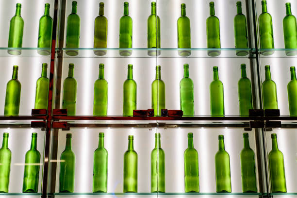 istock rows of empty green wine bottles are displayed on glass shelves against a brightly lit wall 963126480