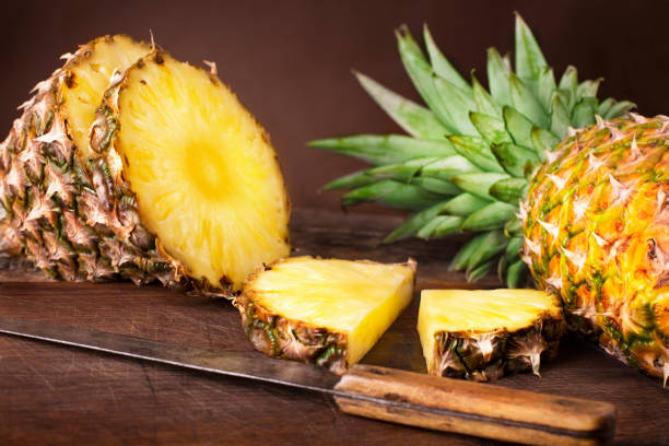 istock pineapples on wooden background 963131412