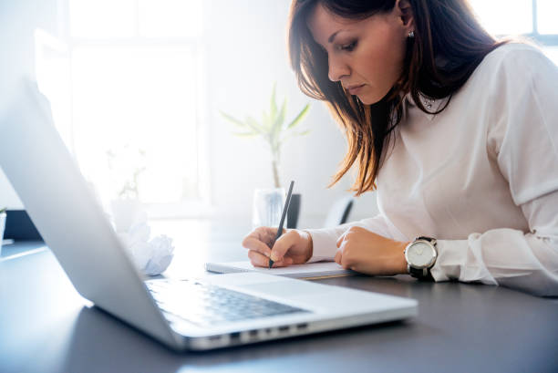 istock Woman in a white suit writing in her clipboard. 963132194