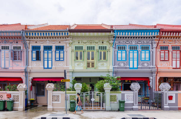 Brightly colored traditional shophouses lining a street in Little India, Singapore, under a clear blue sky. Vibrant architecture, cultural heritage, and urban travel atmosphere representing Southeast Asian city life, diversity, and tourism.