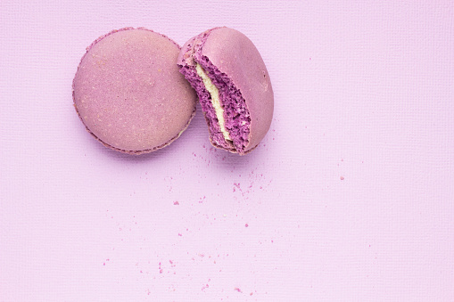 Creative photo of macaroons on purple background.