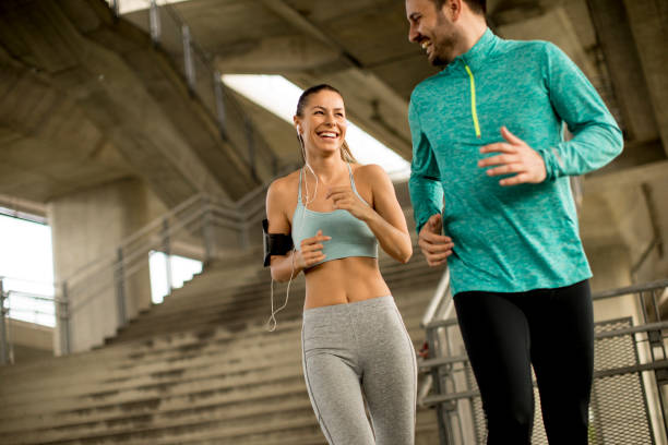 istock Young couple running in urban enviroment 963140656