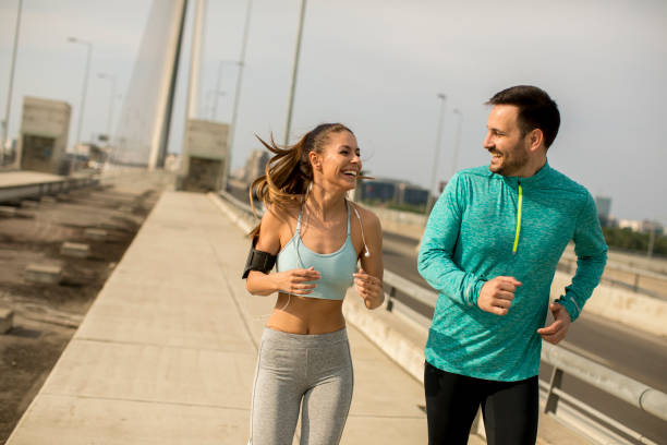 istock Young couple running in urban enviroment 963140690