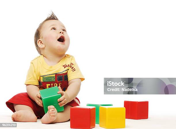 Baby In Yellow Shirt Playing With Blocks Looking Up Surprised Stock Photo - Download Image Now