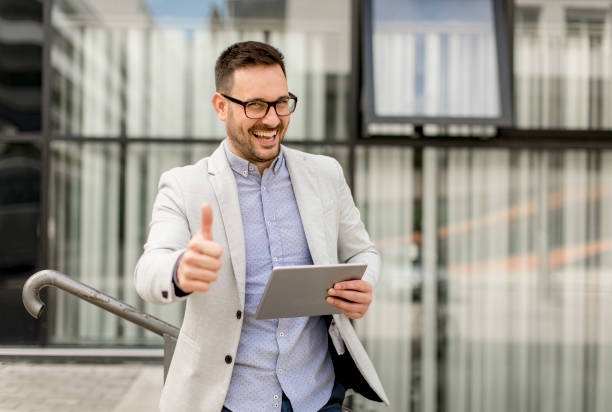 istock Young businessman with digital tablet by the office building 963142584