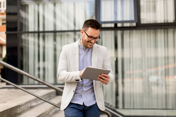 istock Young businessman with digital tablet by the office building 963142590