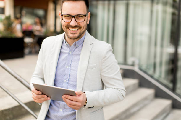istock Young businessman with digital tablet by the office building 963142598