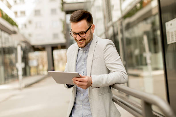 istock Young businessman with digital tablet by the office building 963142610
