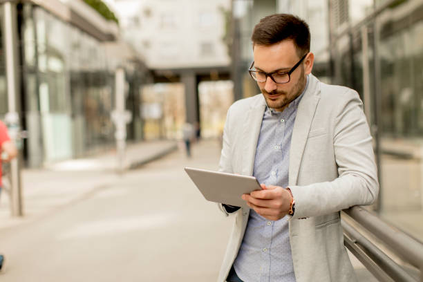 istock Young businessman with digital tablet by the office building 963142612