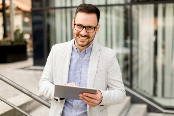 istock Young businessman with digital tablet by the office building 963142626
