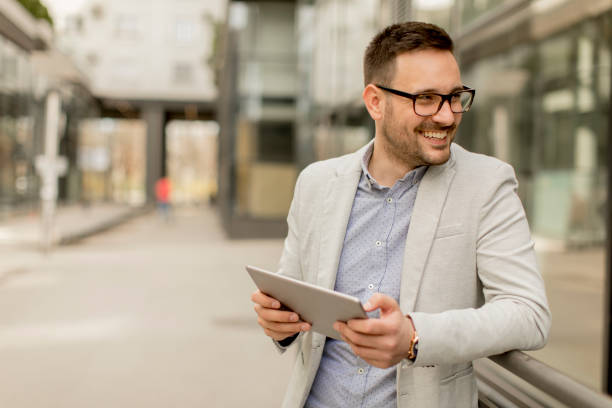 istock Young businessman with digital tablet by the office building 963142636