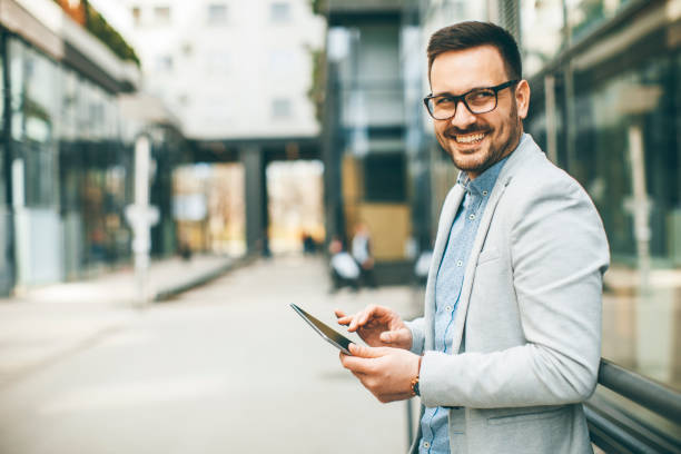 istock Young businessman with digital tablet by the office building 963142640