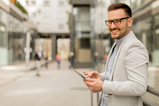 istock Young businessman with digital tablet by the office building 963142660