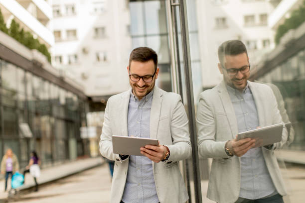 istock Young businessman with digital tablet by the office building 963142670