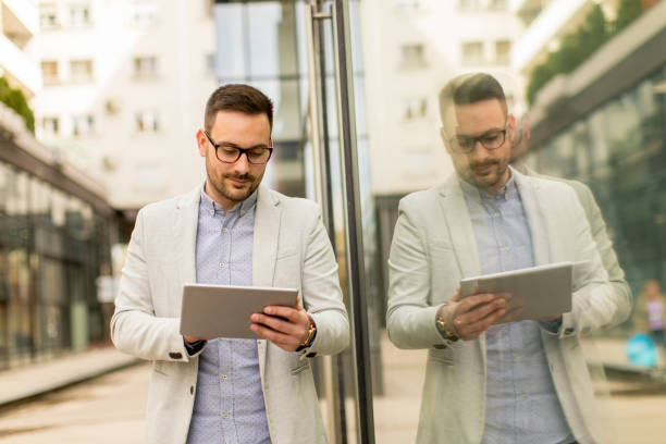 istock Young businessman with digital tablet by the office building 963142682
