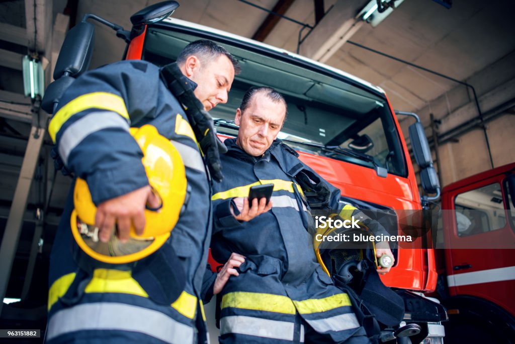 Fireman with radio set Firefighters using smart phone. Firefighter Stock Photo