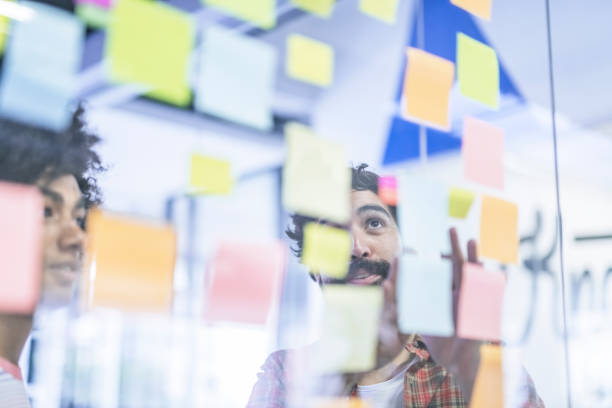 istock Male colleagues discussing over adhesive notes 963152988