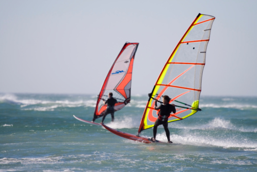 two windsurfer,blue sea,colourful sails