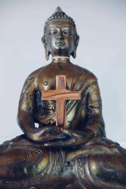 istock Crucifix in the arms of a buddha statue 963159722