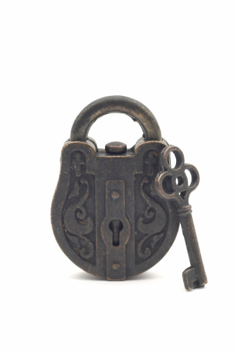 Old vintage key and padlock on a rusty grunge metal background. Escape room game concept.