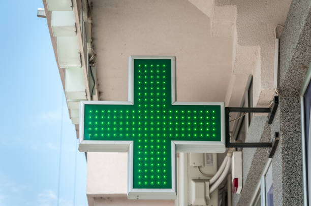 verde cruz farmácia sinal ou símbolo na fachada do edifício vista da rua - green cross - fotografias e filmes do acervo