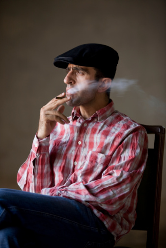 Cropped portrait of a serious elegant man smoking a cigar