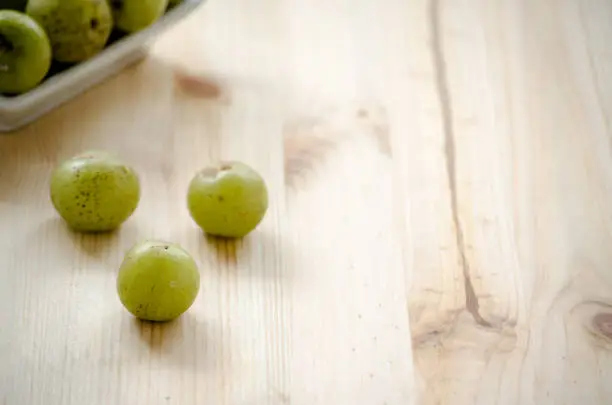 Indian Gooseberry: berry of high vitamin-c on the wooden background