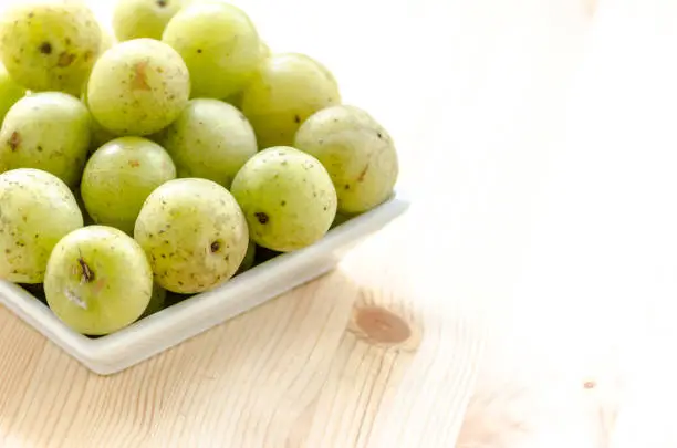 Indian Gooseberry: berry of high vitamin-c on the wooden background
