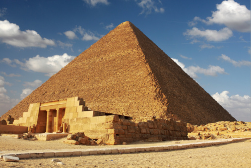 Bedouins riding on camels, pyramids on the background, Giza, Egypt.