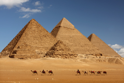 Pyramid of Khafre, Giza - October 8, 2023:  Egyptian man climbing the camel in front of the pyramid of Khafre (or the pyramid of Chephren) in Giza. Egypt, north Africa.